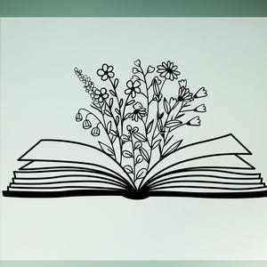 May include: A black and white line drawing of an open book with a bouquet of flowers growing out of the pages.