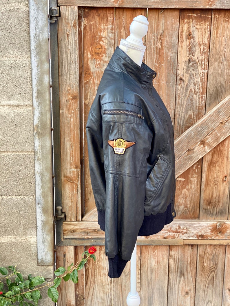 Puede incluir: Chaqueta de cuero negra con cierre de cremallera y un parche con el logotipo de Harley Davidson en el lado izquierdo. La chaqueta tiene un cuello, pu&ntilde;os y dobladillo de punto de canal&eacute;.