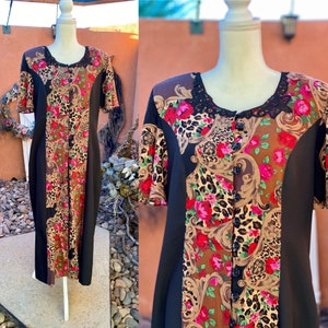 May include: A long black dress with a floral and leopard print. The dress has a button-up front and a lace trim around the neckline.