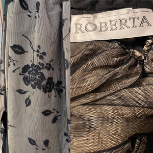 May include: A black and gold sheer fabric with a floral pattern. The fabric has a label that says "ROBERTA".
