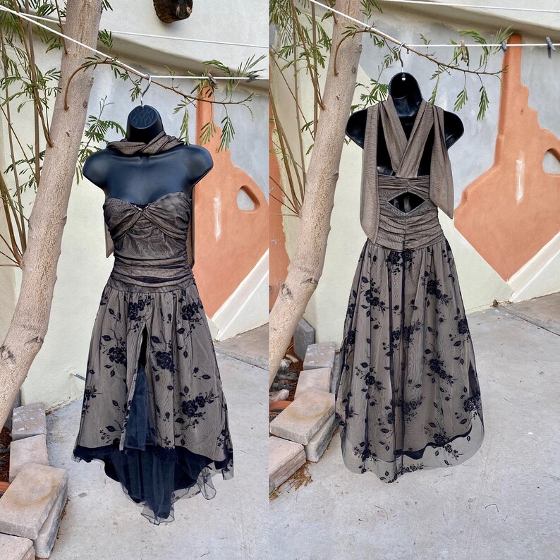 May include: A brown and black formal dress with a floral pattern and a criss-cross halter strap. The dress has a fitted bodice and a full skirt.