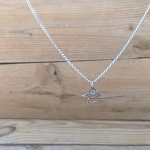 May include: A silver chain necklace with a small angel pendant.