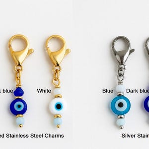 Pu&ograve; includere: Ciondoli in acciaio inossidabile dorati e argentati con perline a forma di occhio blu, blu scuro e bianco. Ogni ciondolo ha un moschettone. I ciondoli sono progettati con piccole perline rotonde.