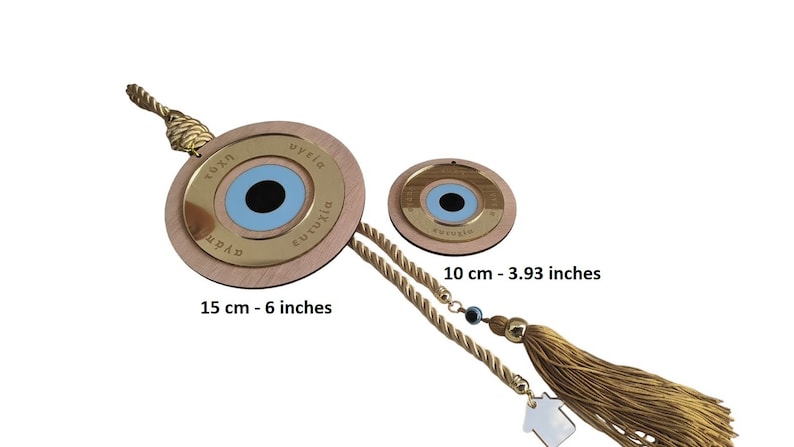 May include: Two wooden evil eye wall hangings with gold trim and blue eyes. The larger one is 6 inches in diameter and the smaller one is 3.93 inches in diameter. Both have Greek text around the eye that says "tychi", "ygeia", "eutychia", and "agapi".