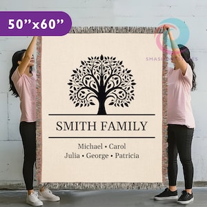Puede incluir: Una manta tejida beige, de 127 cm x 152 cm, con un diseño de árbol negro y las palabras "SMITH FAMILY". Debajo del nombre de la familia están los nombres Michael, Carol, Julia, George y Patricia. La manta tiene un borde con flecos.