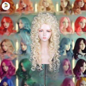 May include: A mannequin head with a long, curly, light blonde wig. The wig is styled with voluminous ringlets. Other wigs in various colors are visible in the background, including red, pink, and blue.