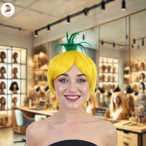 May include: A yellow wig styled to resemble a pineapple, with a green leafy top. The wig is worn by a person in a shop setting. The wig is a bright, solid yellow color, and the green leaves are a darker shade. The person is smiling.