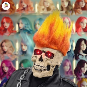 May include: A skull mask with glowing red eyes and a flame-like orange and yellow hairpiece. The mask is part of a costume, with a black leather jacket and chain. The background features mannequin heads with various coloured wigs.