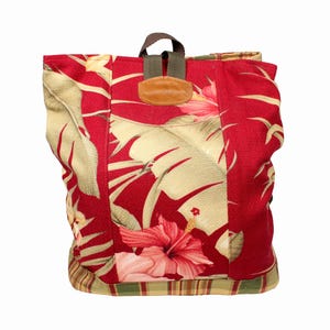May include: Red and green floral print backpack with a brown leather patch and adjustable straps.