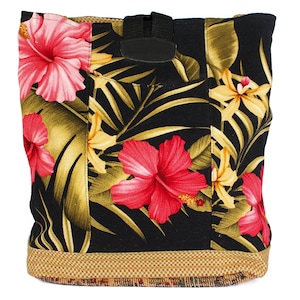Puede incluir: Una bolsa de lona negra con estampado tropical que presenta flores de hibisco rosas, hojas verdes y flores amarillas. La bolsa tiene un ribete a cuadros marrón y beige y una correa negra con hebilla.