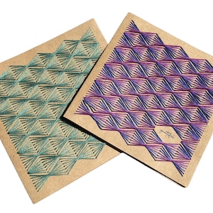 Op de afbeelding: Twee vierkante kaarten met geometrische ontwerpen. Eén kaart heeft een turquoise en groen patroon, de andere een paars en blauw ontwerp. Het woord "grateful" staat rechtsonder op de paarse kaart.
