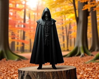 以下が含まれることがあります： 黒いフード付きのマントを着た人が、森の中の切り株の上に立っています。背景は、オレンジ、イエロー、レッドの秋の葉がぼやけています。
