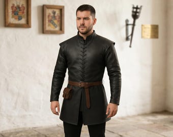 May include: A black long-sleeved tunic featuring a high collar and a central vertical lace-up closure with black cord. The garment is cinched at the waist with a brown leather belt that includes a small attached pouch on the right side.