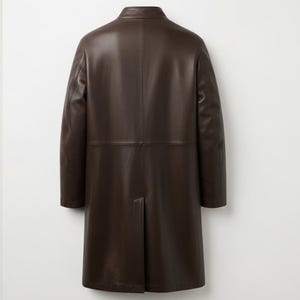 May include: A dark brown leather coat with a classic design. The coat has a notched collar, long sleeves, and a knee-length hem. The back of the coat features a center vent for ease of movement. The coat is made of a smooth, supple leather.
