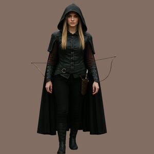 May include: A woman wearing a black hooded cloak with a long black cape, a black leather vest with a zipper closure, and black pants. She is holding a bow and arrow in her right hand.