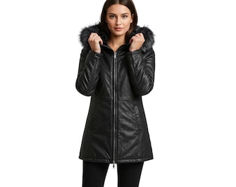 May include: A black, mid-length coat with a faux fur-trimmed hood. The coat features a textured, leather-like appearance, a full-length zipper, and a tailored fit. The model is wearing black pants. This outerwear is suitable for cold weather.