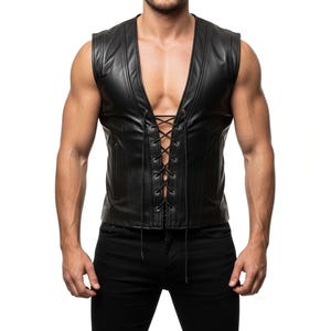 May include: Black leather vest with a lace-up front. The vest has a V-neck and vertical seams. The model is wearing black trousers. The vest is a stylish piece of apparel.