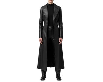 Può includere: Un cappotto lungo in pelle nera con una vestibilità sartoriale. Il cappotto presenta un revers a lancia, una chiusura a un bottone e una gonna lunga e fluida. La modella indossa un dolcevita nero e pantaloni neri.