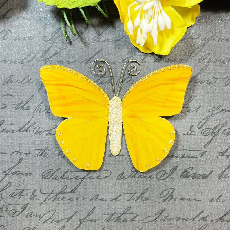 Yellow paper butterfly embellishment.