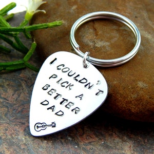 May include: Silver guitar pick keyring with the text "I couldn't pick a better dad" and a small guitar graphic.