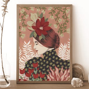 Pode incluir: Uma impressão artística emoldurada com uma mulher de cabelo ruivo adornada com flores. A obra de arte tem uma paleta de cores quentes com tons de vermelho, verde e creme. A mulher usa um top com estampa preta e verde, com motivos florais e vegetais.
