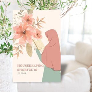 May include: A pink and white floral design with a woman in a pink headscarf reading a book. The text "HOUSEKEEPING SHORTCUTS JOURNAL" is printed below the image.