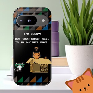 May include: A black phone case with a pixelated cat design. The case features the text "I'M SORRY! BUT YOUR BRAIN CELL IS IN ANOTHER BOX!" and a QR code. The case has a geometric pattern in shades of blue, green, and brown.