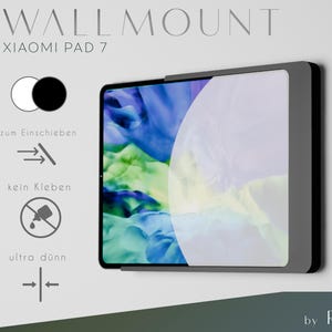 May include: A black wall mount for a Xiaomi Pad 7 tablet. The mount is designed to be inserted into the wall, not glued. The text on the mount reads "WALLMOUNT XIAOMI PAD 7" and "ultra dünn" (ultra thin).