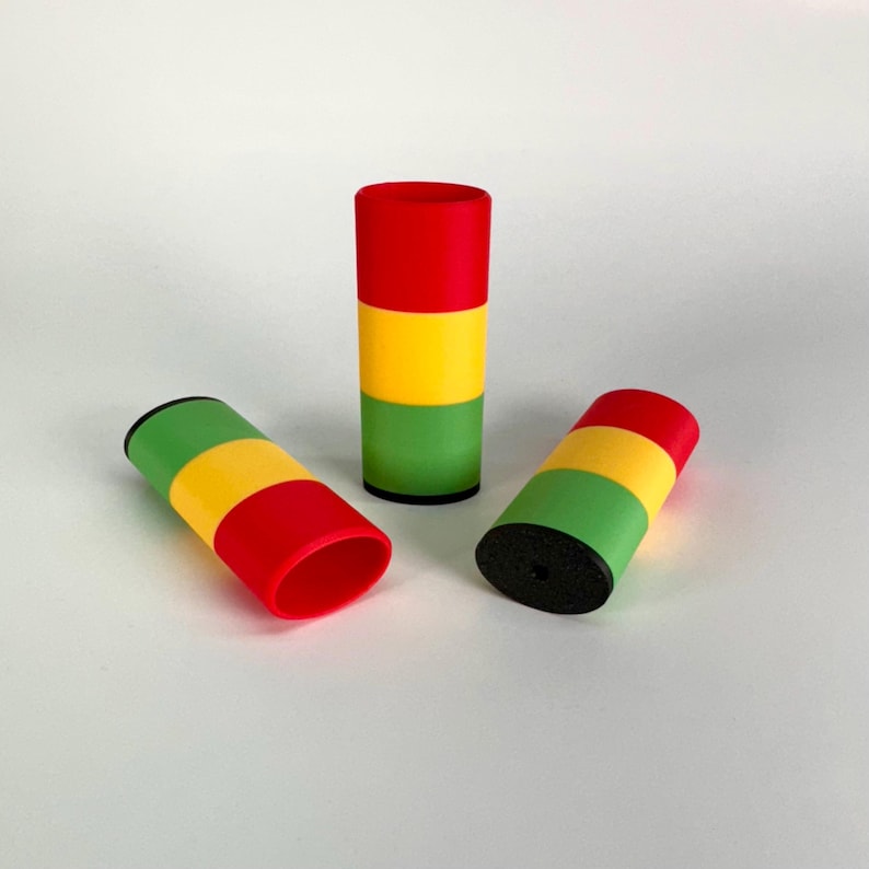 May include: Three cylindrical objects with a red, yellow, and green striped pattern. The objects are made of a smooth, plastic-like material.