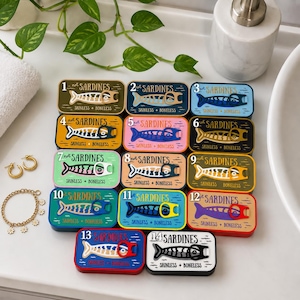 May include: Fourteen rectangular tins labeled 1 through 14 with the text "not SARDINES" and "SKINLESS + BONELESS". Each tin features a stylized fish graphic with a pull-tab ring. The tins are arranged in a grid with various colorful backgrounds.