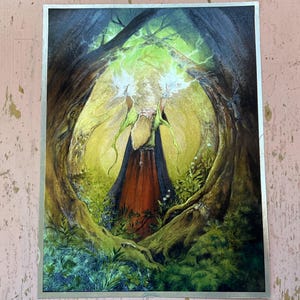 May include: A fantasy art print featuring a wizard in a forest clearing. The wizard, with a long white beard and a red and black robe, is surrounded by lush green foliage and glowing light. The artwork has a silver border.