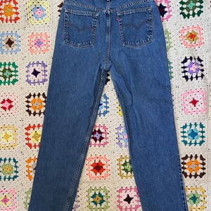 May include: A pair of blue denim jeans with a red Levi's label on the back pocket.