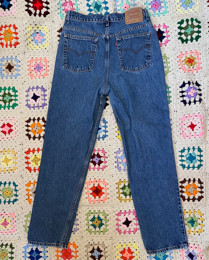 May include: A pair of blue denim jeans with a red Levi's label on the back pocket.