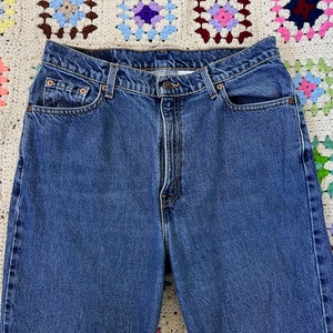 May include: A pair of blue denim jeans with a classic five-pocket style. The jeans have a high waist and a straight leg.