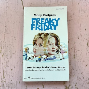May include: A vintage paperback book titled "Freaky Friday" by Mary Rodgers. The cover features a blue title and an illustration of two faces. The book is a Walt Disney Studio's New Movie starring Barbara Harris, Jodie Foster, and John Astin.