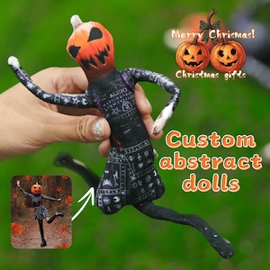 May include: A handmade doll with a pumpkin head and black clothing. The doll has long arms and legs, with white accents on the hands. The text "Custom abstract dolls" is displayed in orange. The image also includes the text "Merry Christmas! Christmas gifts".
