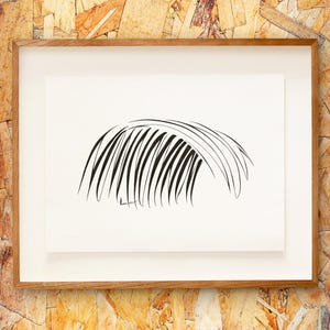 Puede incluir: Una impresión artística enmarcada con un dibujo lineal abstracto en blanco y negro. La obra representa una serie de líneas curvas y paralelas que se asemejan a una fronda de palmera estilizada. La impresión está sobre un fondo blanco, dentro de un marco de madera, montada sobre una superficie texturizada de color marrón claro.