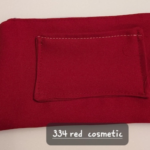 May include: A red cosmetic bag with a smaller pocket stitched on the front. The bag is a solid, deep red color with a textured fabric. The text "334 red cosmetic" is at the bottom.