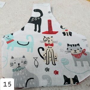 May include: White fabric with a cat print design. The fabric features various cats in different poses and colors, including black, gray, and brown. The fabric also includes a red cat scratching post and a fish.