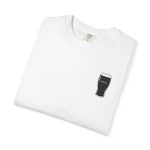 Unisex white t-shirt featuring a minimalist pint glass and the word “Sláinte,” meaning “health” in Irish, printed on the left chest. Perfect for St. Patrick’s Day, pub crawls, beer lovers, Guinness fans, and anyone who enjoys Irish culture. Made with soft garment-dyed cotton and a relaxed unisex fit, it’s a fun and comfortable drinking shirt for parties, casual outfits, and great as a gift for men and women who love beer and Ireland. Keywords: beer gift, beer shirt, guinness shirt, Irish pint