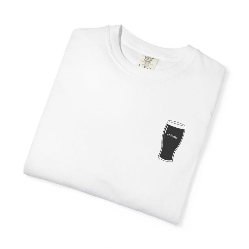 Unisex white t-shirt featuring a minimalist pint glass and the word “Sláinte,” meaning “health” in Irish, printed on the left chest. Perfect for St. Patrick’s Day, pub crawls, beer lovers, Guinness fans, and anyone who enjoys Irish culture. Made with soft garment-dyed cotton and a relaxed unisex fit, it’s a fun and comfortable drinking shirt for parties, casual outfits, and great as a gift for men and women who love beer and Ireland. Keywords: beer gift, beer shirt, guinness shirt, Irish pint