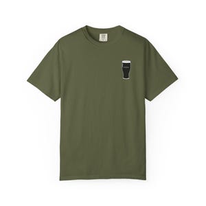 Unisex white t-shirt featuring a minimalist pint glass and the word “Sláinte,” meaning “health” in Irish, printed on the left chest. Perfect for St. Patrick’s Day, pub crawls, beer lovers, Guinness fans, and anyone who enjoys Irish culture. Made with soft garment-dyed cotton and a relaxed unisex fit, it’s a fun and comfortable drinking shirt for parties, casual outfits, and great as a gift for men and women who love beer and Ireland. Keywords: beer gift, beer shirt, guinness shirt, Irish pint