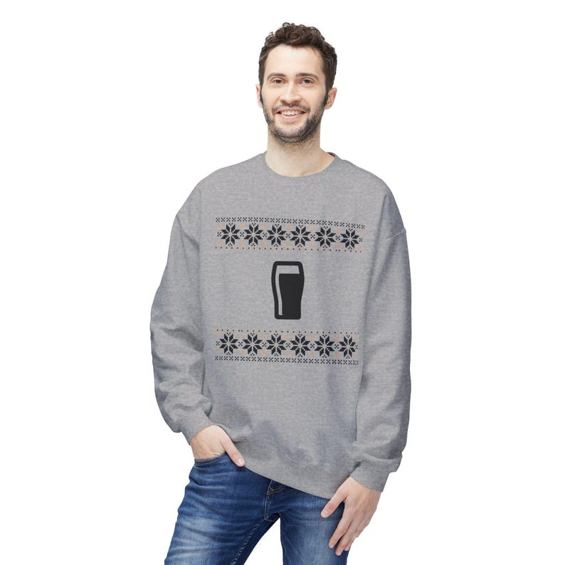 Cozy holiday sweatshirt featuring a simple black pint glass design surrounded by festive knit-style snowflakes. Perfect for beer lovers, stout fans, and anyone who enjoys a classic winter look. Unisex white or gray sweatshirt with a soft, brushed interior and relaxed fit — ideal for Christmas parties, pub nights, or lounging by the fire. Eco-friendly materials and durable design for lasting comfort and holiday cheer. Keywords: guinness christmas sweater, beer lover gift, beer christmas gift