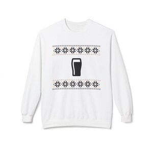 Cozy holiday sweatshirt featuring a simple black pint glass design surrounded by festive knit-style snowflakes. Perfect for beer lovers, stout fans, and anyone who enjoys a classic winter look. Unisex white or gray sweatshirt with a soft, brushed interior and relaxed fit — ideal for Christmas parties, pub nights, or lounging by the fire. Eco-friendly materials and durable design for lasting comfort and holiday cheer. Keywords: guinness christmas sweater, beer lover gift, beer christmas gift