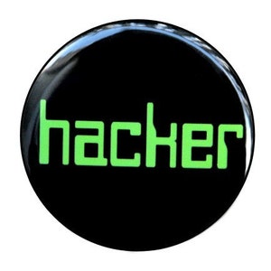 May include: A black button with the word "hacker" in green letters.
