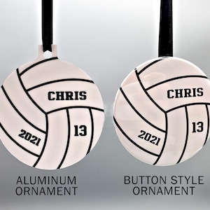 May include: Two volleyball-themed Christmas ornaments, one with a white background and the other with a silver background. Both ornaments feature a black volleyball design with the name "CHRIS" and the number "13" printed on them. The white ornament is labeled "Aluminum Ornament" and the silver ornament is labeled "Button Style Ornament".