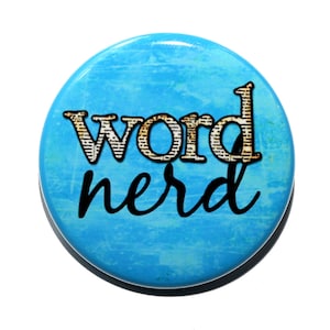 May include: A blue button with the words "word nerd" printed on it. The word "word" is in a vintage font with a newspaper texture.