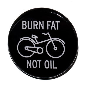 May include: Black and white button with the text "BURN FAT NOT OIL" and a bicycle illustration.