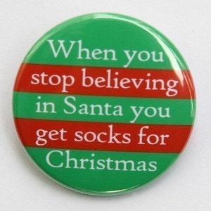May include: A green and red striped button with the text "When you stop believing in Santa you get socks for Christmas".
