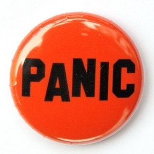 Peut inclure: Bouton rond orange avec le mot "PANIC" imprimé en noir.